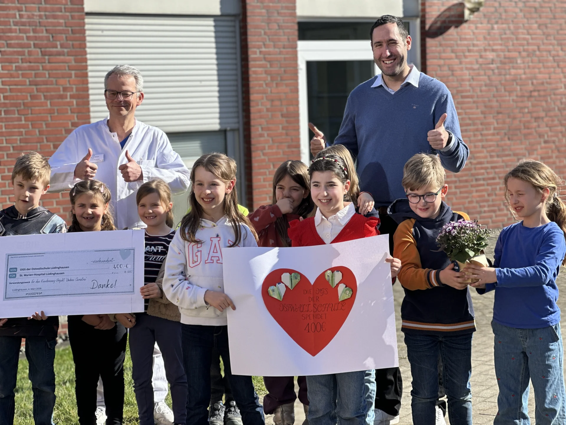 Dr. Marcus Ullmann und Johannes Simon freuen sich sehr über die Spende der Schülerinnen und Schüler der OGS.